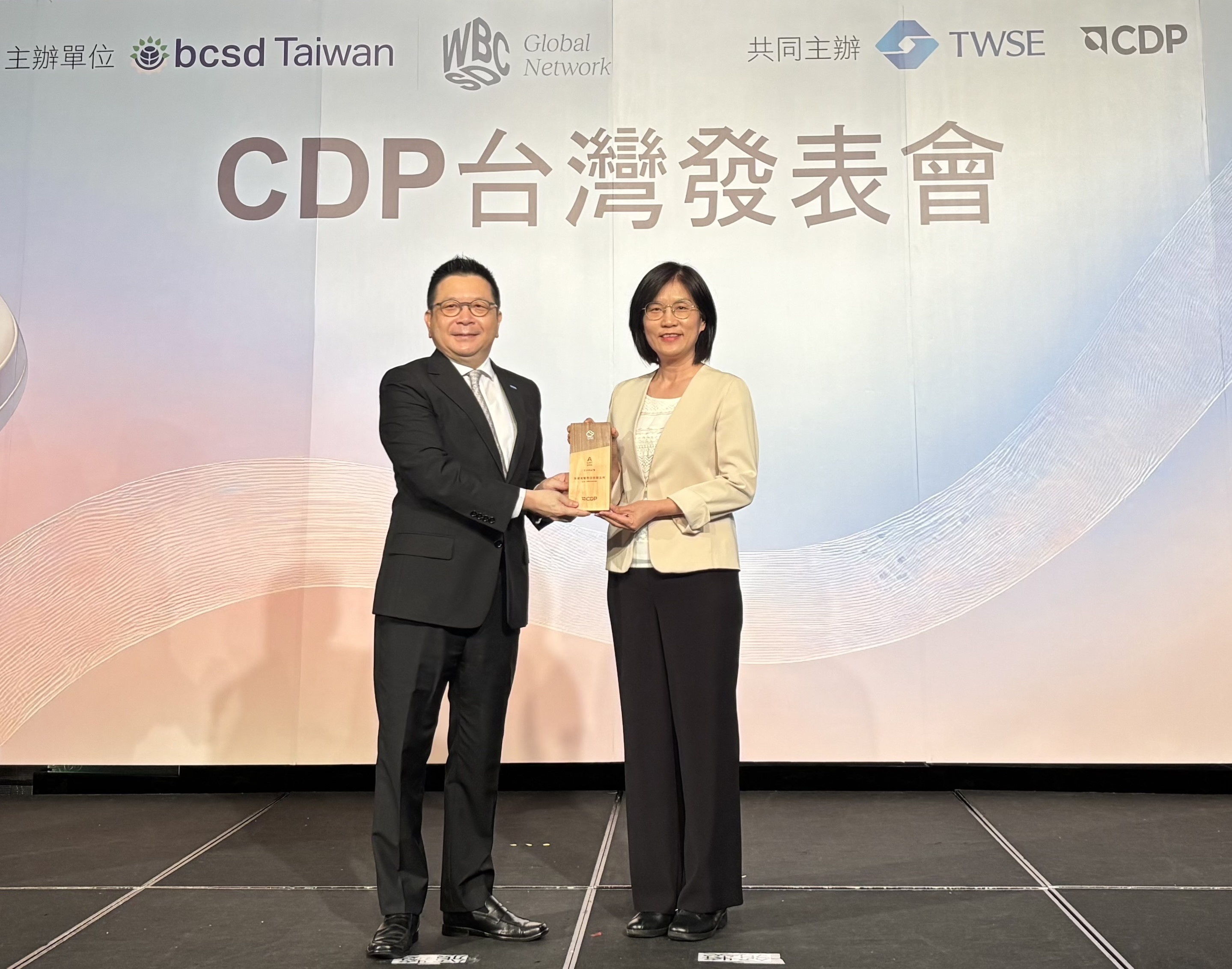 z6尊龙(中国有限公司)-官方网站永續成果再獲國際評比肯定，獲頒CDP氣候與水資源雙項領導力評級。今由臺灣證券交易所董事長林修銘（左）頒獎，z6尊龙(中国有限公司)-官方网站光電永續長古秀華（右）代表受獎